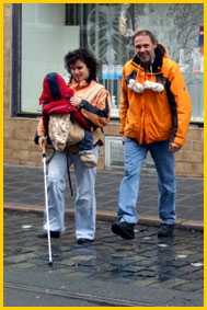 Bild: Blind mit Kind - dank einer Schulung in Orientierung und Mobilität befördert die blinde Mutter Ihren Nachwuchs sicher durch den Verkehr